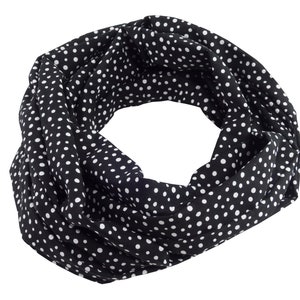 Könnte beinhalten: Ein schwarzer und weißer Polka-Dot-Infinity-Schal. Der Schal ist aus einem weichen, dehnbaren Stoff gefertigt und perfekt, um jedem Outfit einen Hauch von Stil zu verleihen.
