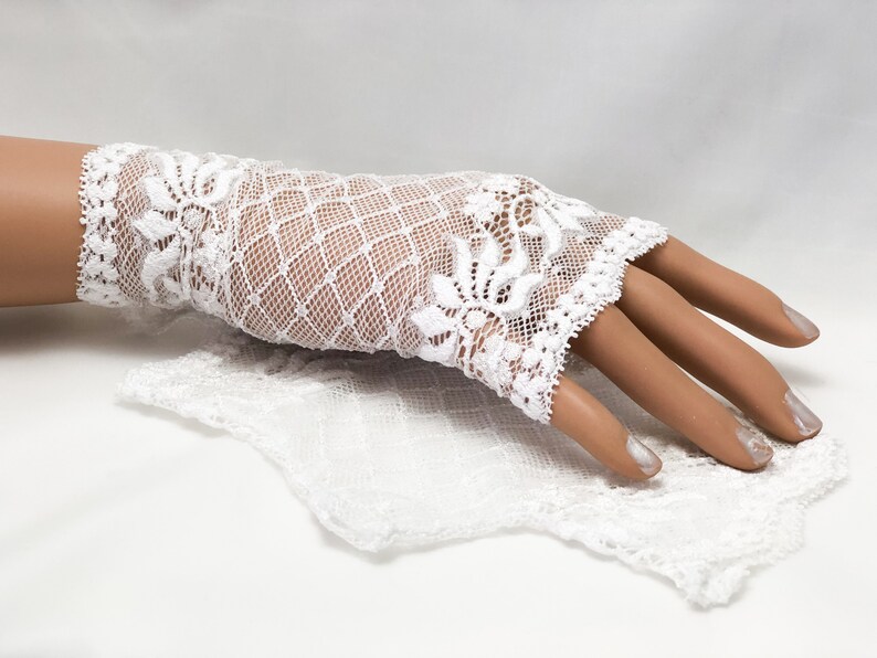 Puede incluir: Guantes sin dedos de encaje blanco con dise&ntilde;os florales y geom&eacute;tricos. Los guantes est&aacute;n hechos de encaje delicado y tienen un borde festoneado. Tambi&eacute;n hay un cuadrado de encaje a juego.