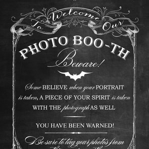 May include: A chalkboard-style sign with white script and ornate borders. The sign reads "Welcome to our Photo Boo-th Beware!" and includes text about portraits and spirits. It also encourages tagging photos with #PUTTINONTHEFRITZ.