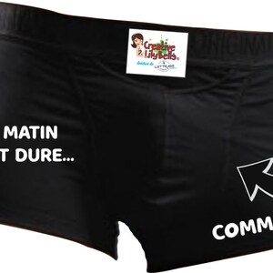 May include: Black underwear with white text that reads "Le matin c'est dure... Comme ça" and an arrow pointing to the right.