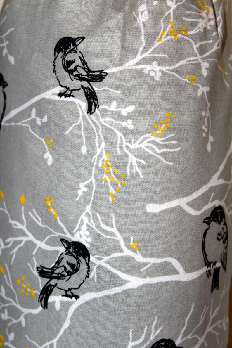 May include: Gray fabric with a white and yellow floral pattern and black silhouettes of birds perched on the branches.