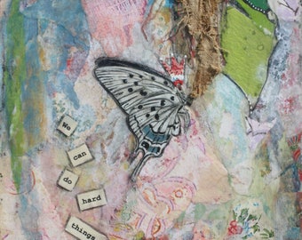 May include: A mixed media art piece with a butterfly, flowers, and the words "We can do hard things." The background is a mix of blue, pink, and green.