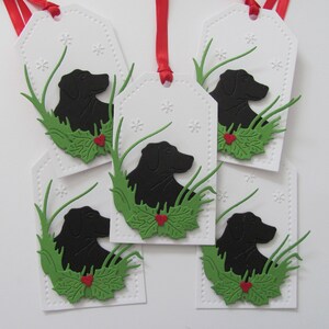 May include: Five white gift tags with black silhouette of a dog's head in green grass with red holly berries.