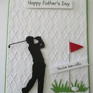 May include: A white card with a green border and a diamond pattern. The card has a black silhouette of a golfer swinging a club. The card also has a red flag, a white banner with the text "You're tee-rific", and green grass with a white golf ball.