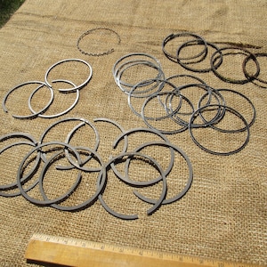 May include: A white ceramic mug with a black handle and the text "But First, Coffee" in a handwritten style. The mug is on a white surface. The mug is approximately 4 inches tall.