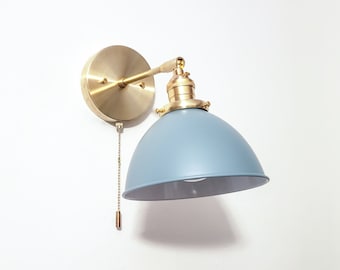 May include: A brass wall sconce with a blue metal shade. The sconce has a chain pull switch.