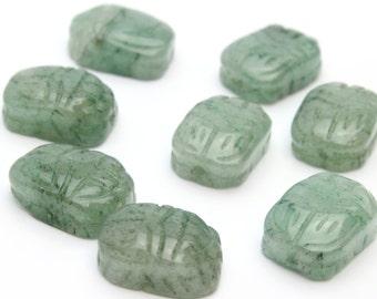 Pode incluir: Uma coleção de oito esculturas de escaravelhos de pedra verde. Cada escaravelho é esculpido com detalhes intrincados e tem uma superfície lisa e polida. As pedras preciosas variam ligeiramente em tonalidade, com algumas mostrando inclusões verdes mais escuras.