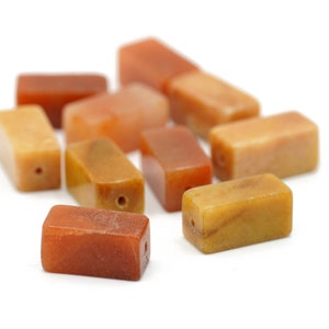 Peut inclure: Dix perles rectangulaires en pierre précieuse dans des tons d'orange, de jaune et de brun. Les perles ont un trou percé au centre pour le perlage.