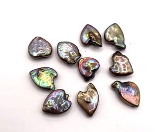 May include: A collection of ten iridescent, irregularly shaped pearls. The pearls display a range of colors, including purple, green, and gold, with a lustrous sheen. Each pearl has a unique, organic form, suggesting they are natural and untreated.