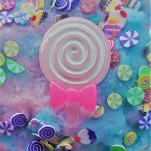 Peut inclure: Une slime rose et bleue avec un charme de sucette rose et des paillettes color&eacute;es. Les paillettes sont en forme de c&oelig;urs, d'&eacute;toiles et de spirales.
