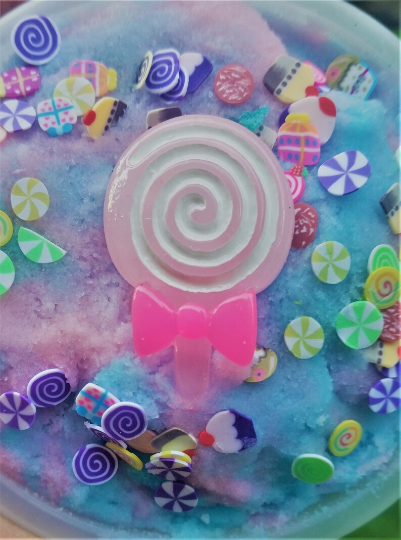 Peut inclure: Une slime rose et bleue avec un charme de sucette rose et des paillettes color&eacute;es. Les paillettes sont en forme de c&oelig;urs, d'&eacute;toiles et de spirales.