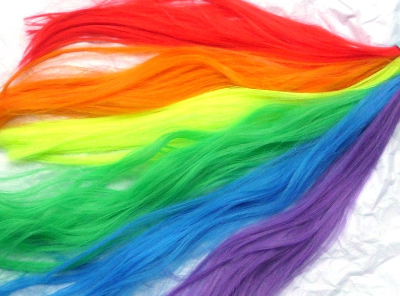 May include: A rainbow of colorful yarn strands, with red, orange, yellow, green, blue, and purple colors.