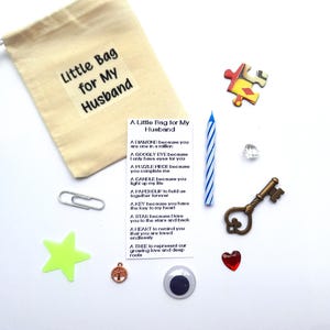 May include: A small white drawstring bag with the text "Little Bag for My Husband" printed on it. The bag is filled with small items, including a googly eye, a puzzle piece, a key, a star, a heart, a tree, and a candle. A card with the text "A Little Bag for My Husband" is also included, with a list of reasons why the recipient is special.
