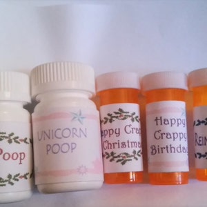 May include: Five small white and orange pill bottles with humorous labels. The labels read "Elf Poop", "Unicorn Poop", "Happy Crappy Christmas", "Happy Crappy Birthday", and "Reindeer Poop".