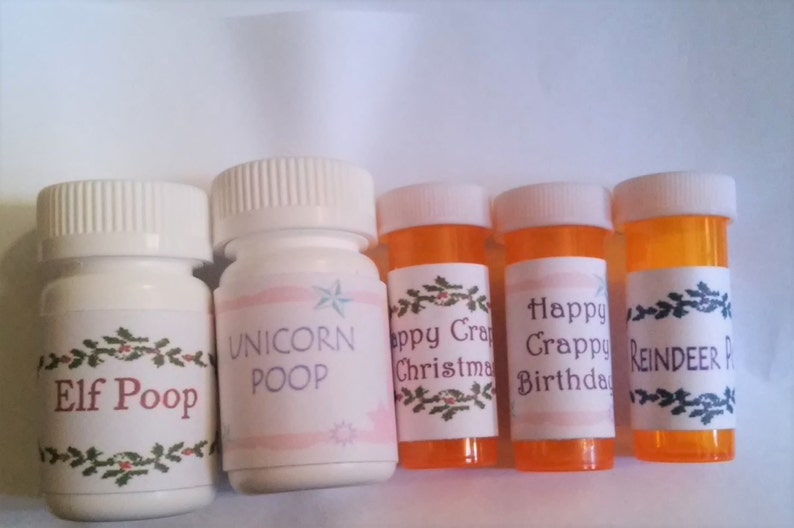 May include: Five small white and orange pill bottles with humorous labels. The labels read "Elf Poop", "Unicorn Poop", "Happy Crappy Christmas", "Happy Crappy Birthday", and "Reindeer Poop".