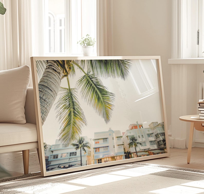 South Beach photography print showing 3 Art Deco hotels framed under a palm tree on the top left.  Soft pastel colors.