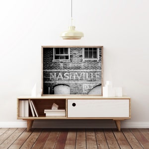 Nashville Photo Print shown framed in black and white (comes unframed). Features the city's name on an old brick building.