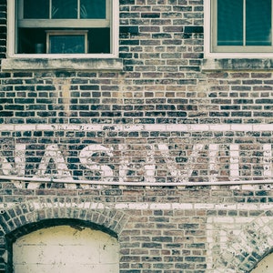 Nashville Photo Print has soft, muted colors of blue and gray.  Features the city's name on an old brick building.