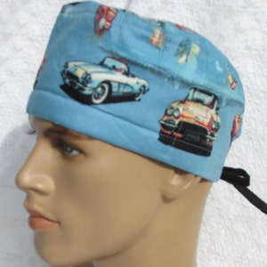 May include: A blue scrub hat with a pattern of vintage cars. The hat has a tie at the back.