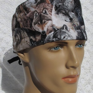 May include: A surgical scrub hat with a wolf print pattern. The hat is made of a soft, comfortable fabric and has a tie closure at the back.