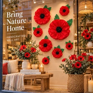May include: A store window display featuring large red paper poppy wall art with black centers and green leaves. Text on the glass reads Bring Nature Home Handcrafted Wall Art. Below are vases with red flowers, a wooden bench, and a woven basket.