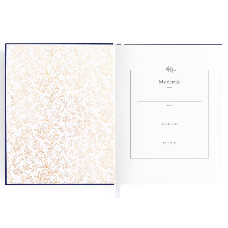 May include: A white journal with a navy blue cover and gold floral pattern. The inside page has a section for "My details." with lines for name, date of birth, and birth place.