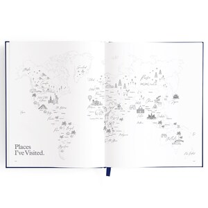 May include: A white open notebook with a world map printed on the pages. The map is in black and white and shows various landmarks and cities around the world. The text "Places I've Visited." is printed on the left page.