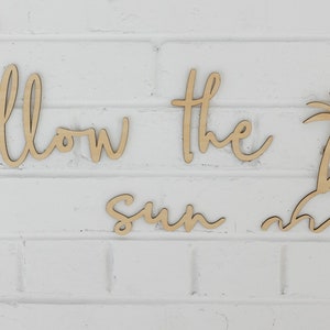 Może przedstawiać: Drewniana dekoracja ścienna z napisem "follow the sun" i palmą z falami u dołu.