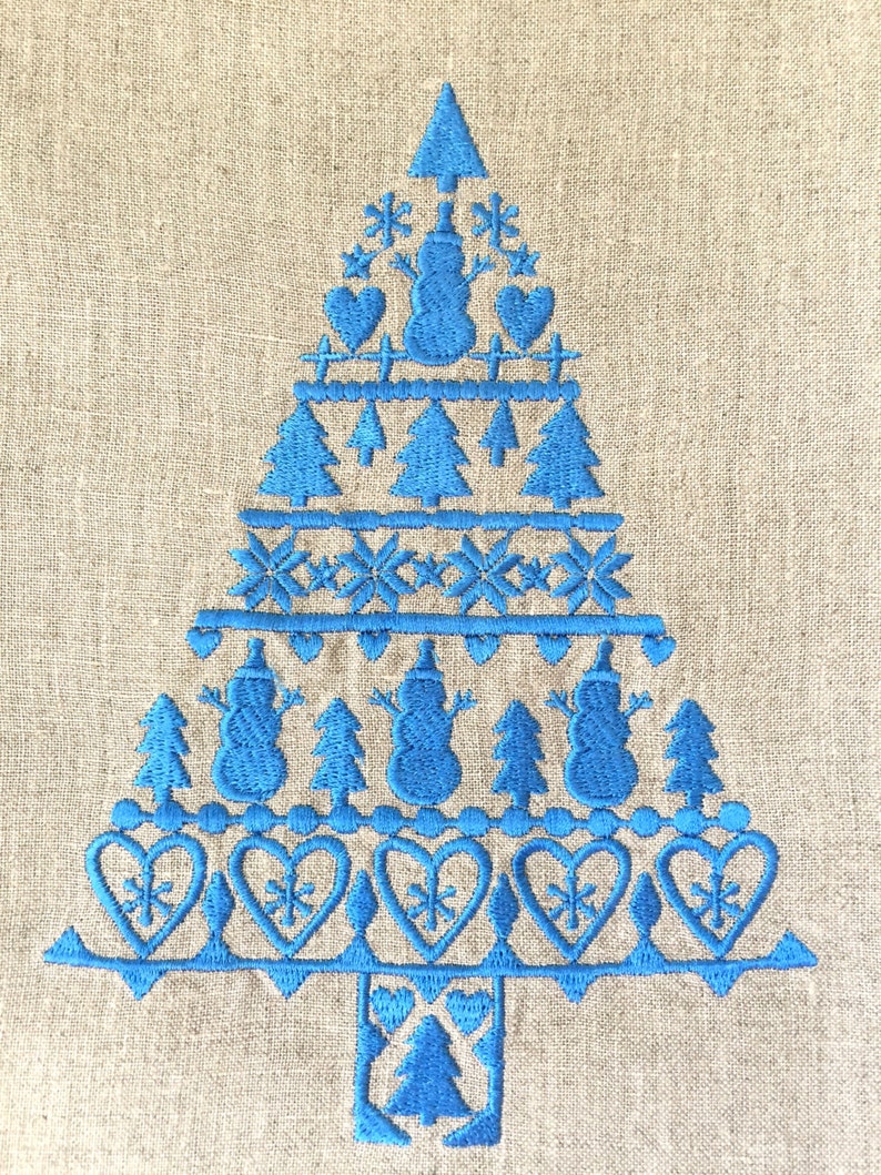 May include: Blue embroidered Christmas tree design on a linen fabric background. The design features snowmen, hearts, snowflakes, and pine trees.