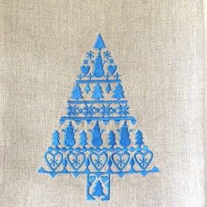 May include: A blue embroidered Christmas tree design on a beige linen kitchen towel. The design features a tree with a star on top, snowmen, hearts, and snowflakes.