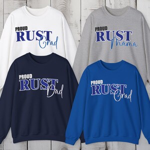 May include: Four sweatshirts in white, navy blue, gray, and royal blue. Each sweatshirt has the text "Proud RUST" with a different word below: "Grad", "Dad", "Mama", and "Grad". The text is in a bold, outlined font.