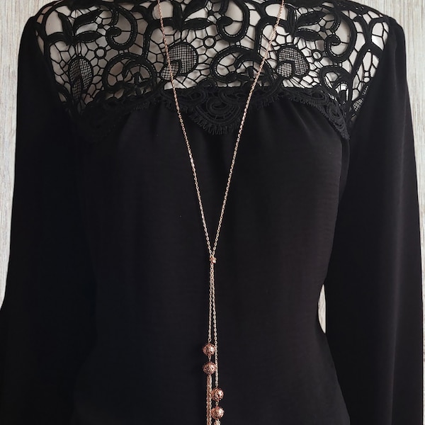 34" long Rose gold tone knotted lariat style necklace with natural lava beads & chain tassel detail