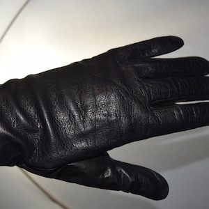May include: A pair of black leather gloves with a textured surface.