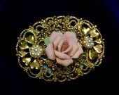 An Intricate Filigree Broach with a Ceramic Rose Bud Mounted on a Blue Oval Salt Cellar
