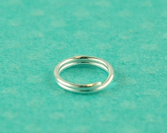 May include: A silver jump ring, a small metal ring used for connecting jewelry components.