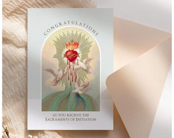May include: A greeting card with a religious image of a heart with a crown of thorns and doves. The text on the card reads "Congratulations as you receive the Sacraments of Initiation."