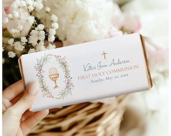 May include: White chocolate bar wrapper with a floral wreath design and a gold chalice. The text reads "Kateri Joan Anderson First Holy Communion Sunday, May 20, 20XX".