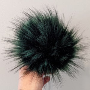 May include: A dark green fluffy pom pom, ideal for adding a touch of whimsy to hats, scarves, or other accessories.