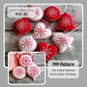 Puede incluir: Una colección de adornos navideños de fieltro en rojo y blanco, con patrones de copos de nieve bordados. Las formas incluyen corazones, campanas y esferas con cintas para colgar. El texto dice 100% Human made NO AI y PDF Pattern FOR HAND SEWING WITH VIDEO TUTORIAL.