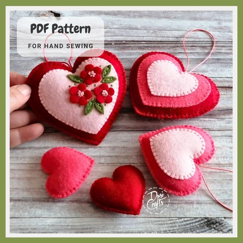 May include: Handmade felt heart ornaments in shades of red and pink. Some hearts are layered, others feature floral embellishments. The text "PDF Pattern For Hand Sewing" is visible. These ornaments are perfect for Valentine's Day or other special occasions.