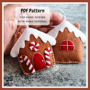 K&ouml;nnte beinhalten: Zwei Filz-Lebkuchenhaus-Ornamente mit wei&szlig;em Zuckerguss, roten T&uuml;ren und Zuckerstangen-Akzenten. Eines hat ein rot-wei&szlig;es Wirbelbonbon. Der Text lautet "PDF Pattern for Hand Sewing with Video Tutorial."