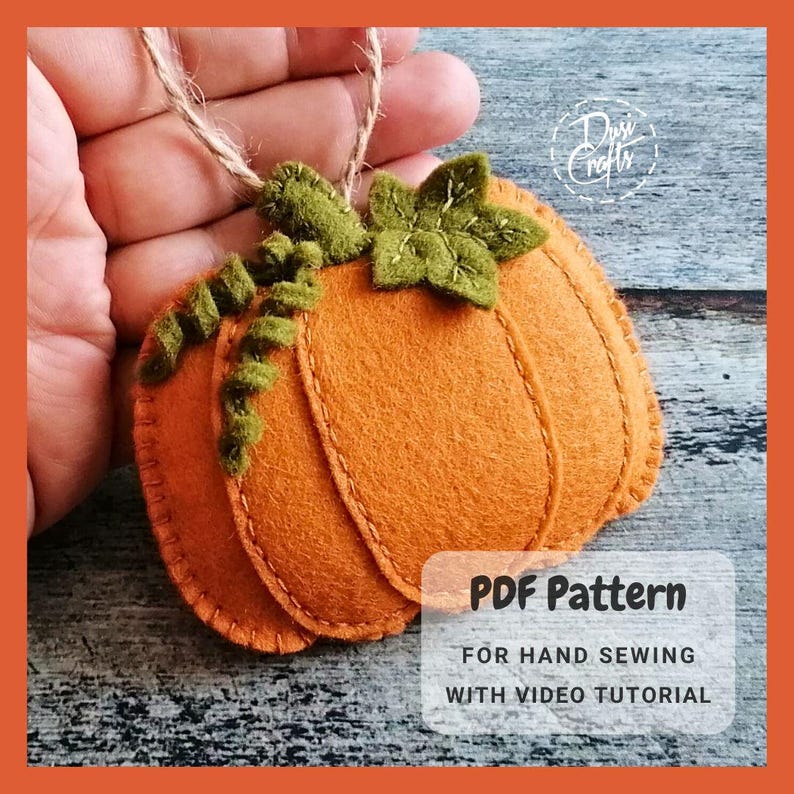 May include: A felt pumpkin ornament with a green stem and leaves. The ornament is hand-sewn and has a rustic, autumnal feel. The image includes the text "PDF Pattern for Hand Sewing with Video Tutorial".