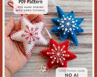 May include: Three star-shaped felt ornaments in white, blue, and red, each featuring embroidered snowflake patterns and white ribbon loops. The white star has red stitching, while the blue and red stars have white stitching and small beads.