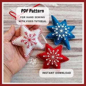Op de afbeelding: Drie vilten sterornamenten in wit, blauw en rood, elk met een sneeuwvlokontwerp. De witte ster heeft rode stiksels en een rode sneeuwvlok. De blauwe ster heeft witte stiksels en een witte sneeuwvlok. De rode ster heeft witte stiksels en een witte sneeuwvlok. De afbeelding bevat de tekst "PDF Pattern" en "Instant Download".