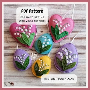 Könnte beinhalten: Handgefertigte Filzornamente in Herz- und Eiform, mit Maiglöckchen-Designs. Die Ornamente sind in verschiedenen Farben wie Rosa, Blau, Lila und Gelb gehalten, mit grünen Blättern und weißen Blüten. Der Text auf dem Bild lautet "PDF Pattern" und "Instant Download."