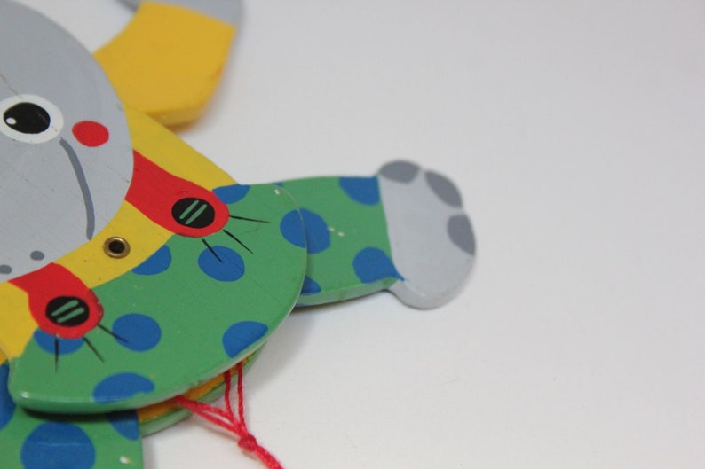 Puede incluir: Un t&iacute;tere de madera de un animal gris con lunares azules, verdes, amarillos y rojos. El t&iacute;tere tiene una cuerda atada a su cabeza.