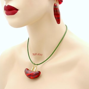 Collier court en cuir avec pendentif, boucles d'oreilles assorties rouges, vertes, multicolores et dorées. Pièce unique en forme de rein, faite main en pâte polymère.