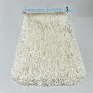 Puede incluir: Borde de flecos blanco de aproximadamente 25 cm de largo. El fleco está hecho de un material suave y sedoso, perfecto para agregar un toque de elegancia a cualquier proyecto.