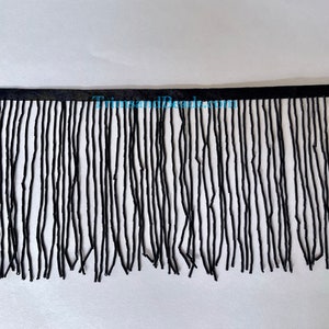 May include: Black beaded fringe trim. The fringe is made of small, round beads that are strung together to create a long, flowing fringe. The fringe is approximately 1 inch in length.