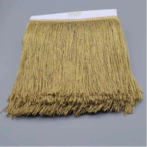 May include: Gold fringe trim with a subtle shimmer. This trim is perfect for adding a touch of glamour to any project.